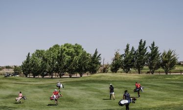 people-walking-on-green-grass-field-carrying-golf-bags-1325682